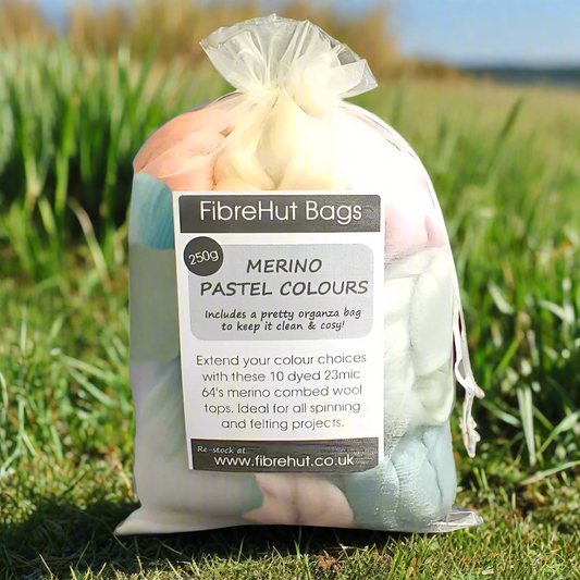 Bag of merino wool in pastel colors with FibreHut Bags packaging on grass